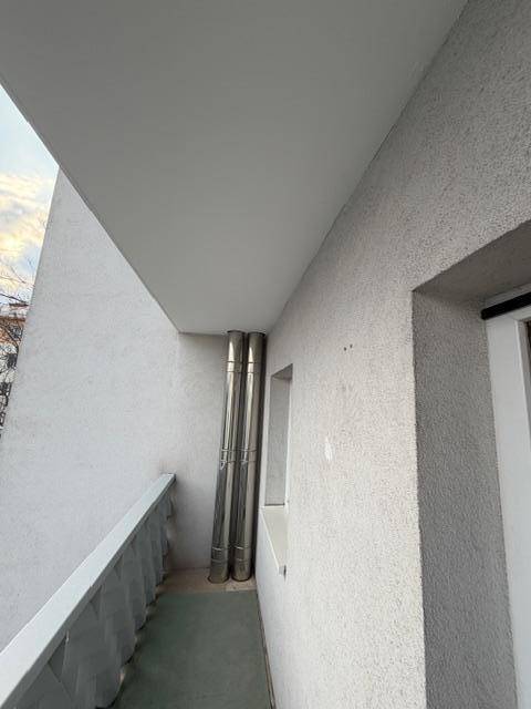 Schmaler Balkon mit Edelstahlrohren und Blick auf die Umgebung.
