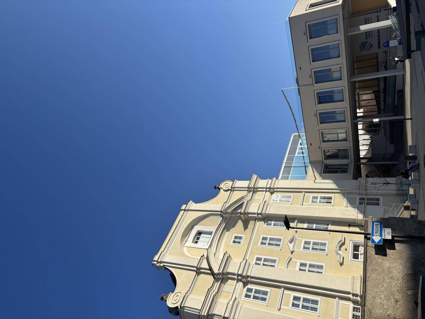Historisches Gebäude mit barocker Fassade unter strahlend blauem Himmel.
