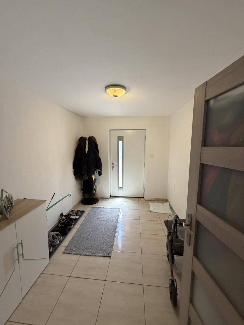 Heller Eingangsbereich mit Fliesenboden, Garderobe und Zugang zu weiteren Räumen.