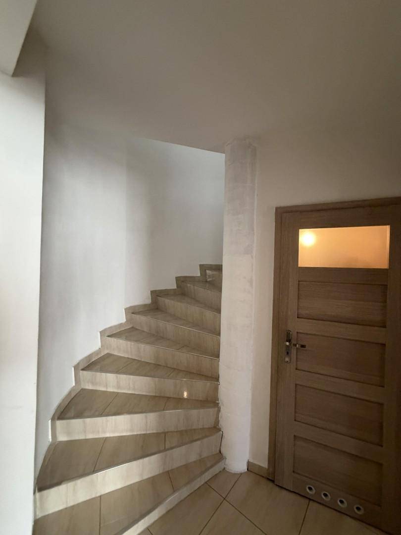 Elegante Wendeltreppe mit hellen Fliesenstufen, die die Stockwerke verbindet.