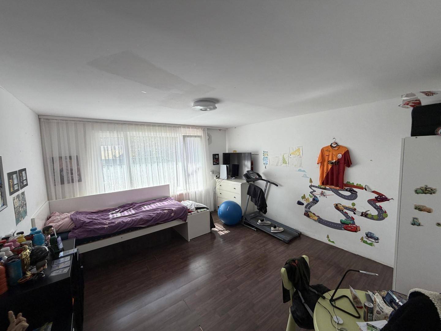 Kinderzimmer mit Bett, Laufband und spielerischer Wanddekoration.