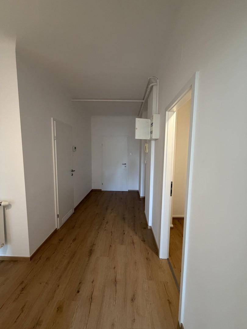 Geräumiger Flur mit Holzboden und mehreren Türen, der die verschiedenen Wohnbereiche verbindet.