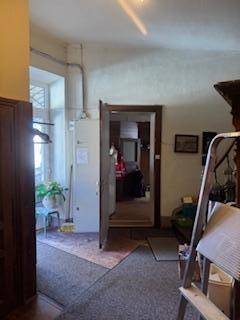 Eingangsbereich mit Holztäfelung, Fenster und Blick in einen weiteren Raum.