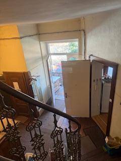 Treppenabsatz mit Blick auf eine Tür, die zu einem Außenbereich oder Balkon führt.