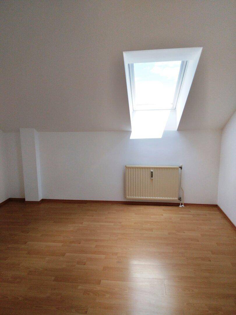 Heller Raum im Dachgeschoss mit Laminatboden und großem Dachfenster für viel Tageslicht.