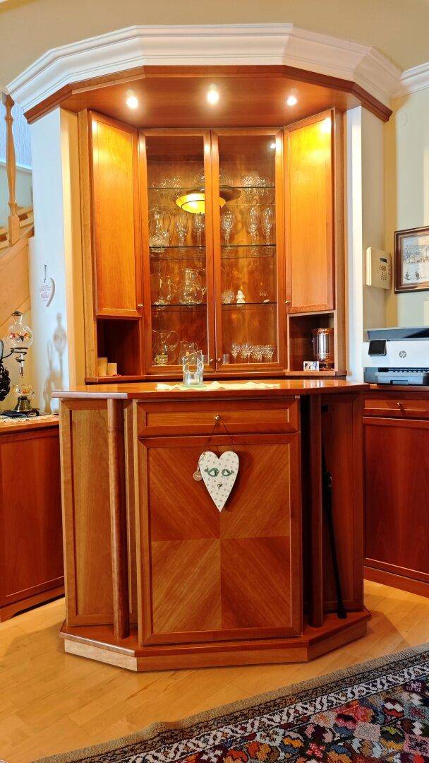 Detailansicht eines eleganten, eingebauten Holzschranks mit Glasvitrine und dekorativen Elementen.