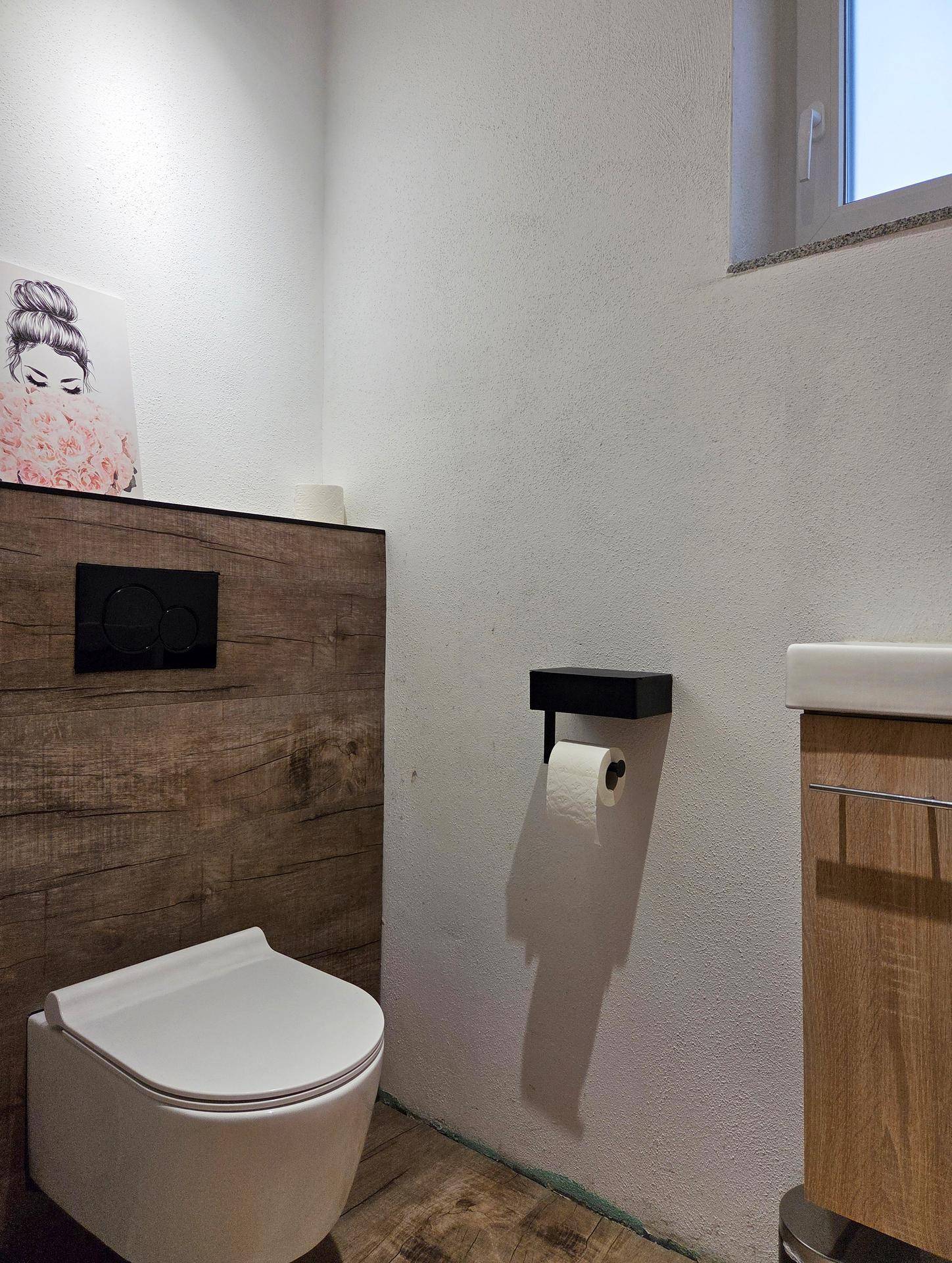 Modernes Gäste-WC mit Wand-WC, Holzverkleidung und kleinem Waschbecken.