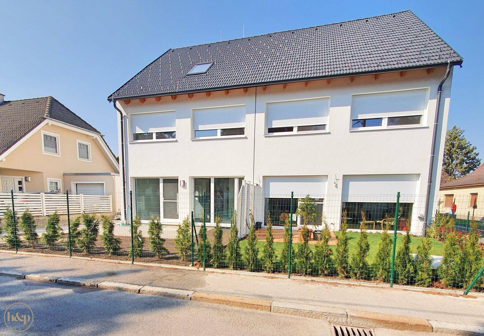 Ansicht des modernen Reihenhauses von der Straße mit neu angelegtem Vorgarten.