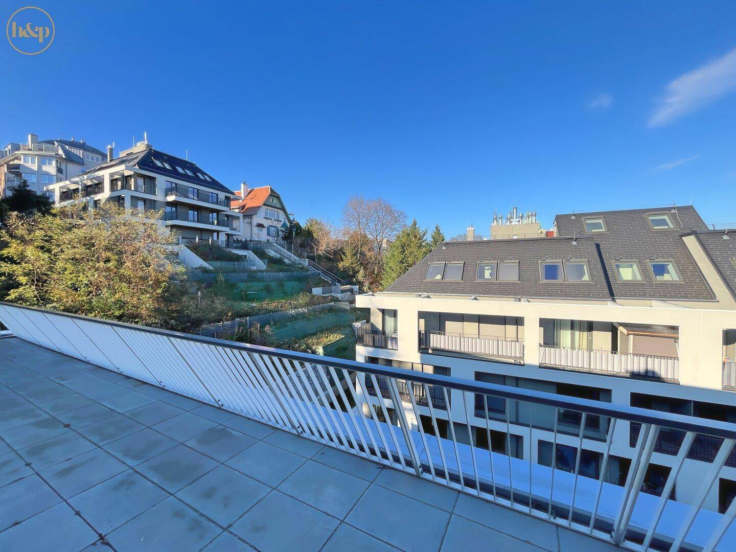 Weitläufiger Ausblick von der Terrasse auf die umliegenden Gebäude und die Natur.