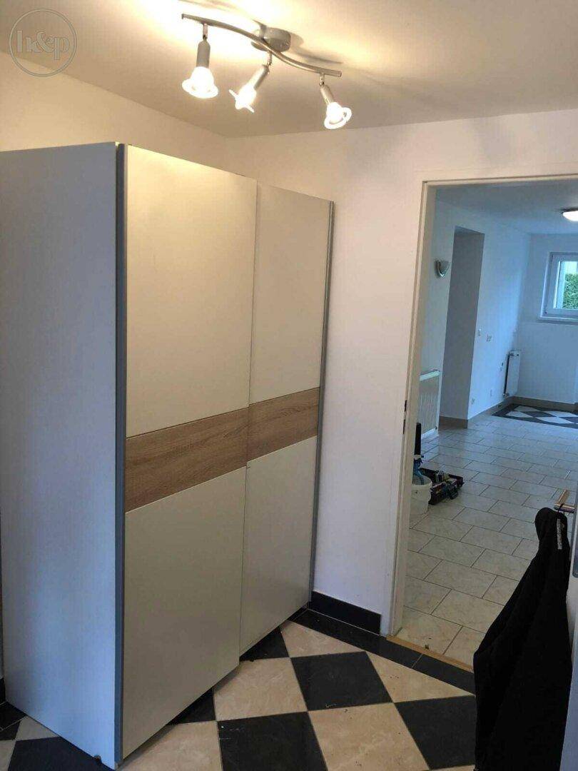 Eingangsbereich mit modernem Kleiderschrank und auffälligem schwarz-weißem Fliesenboden.