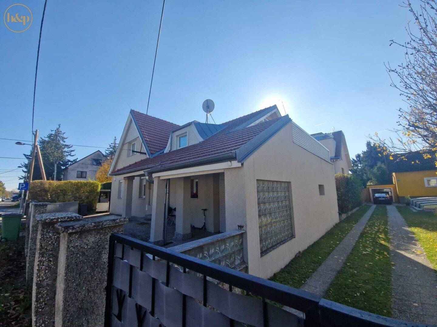 Einfamilienhaus mit Satteldach, gepflegtem Vorgarten und sonniger Auffahrt.