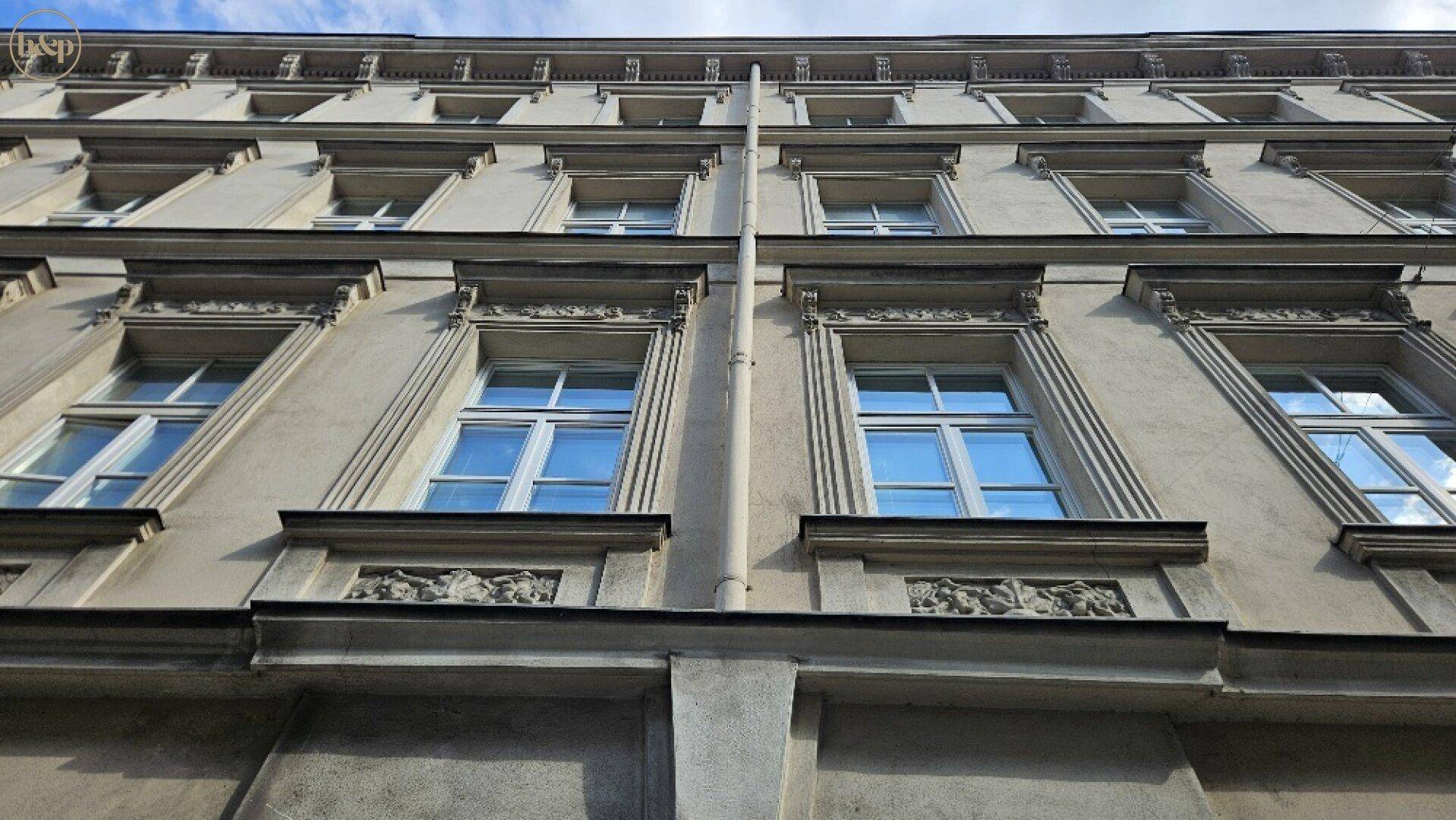 Detailansicht einer historischen Fassade mit verzierten Fenstern und klassischer Architektur.