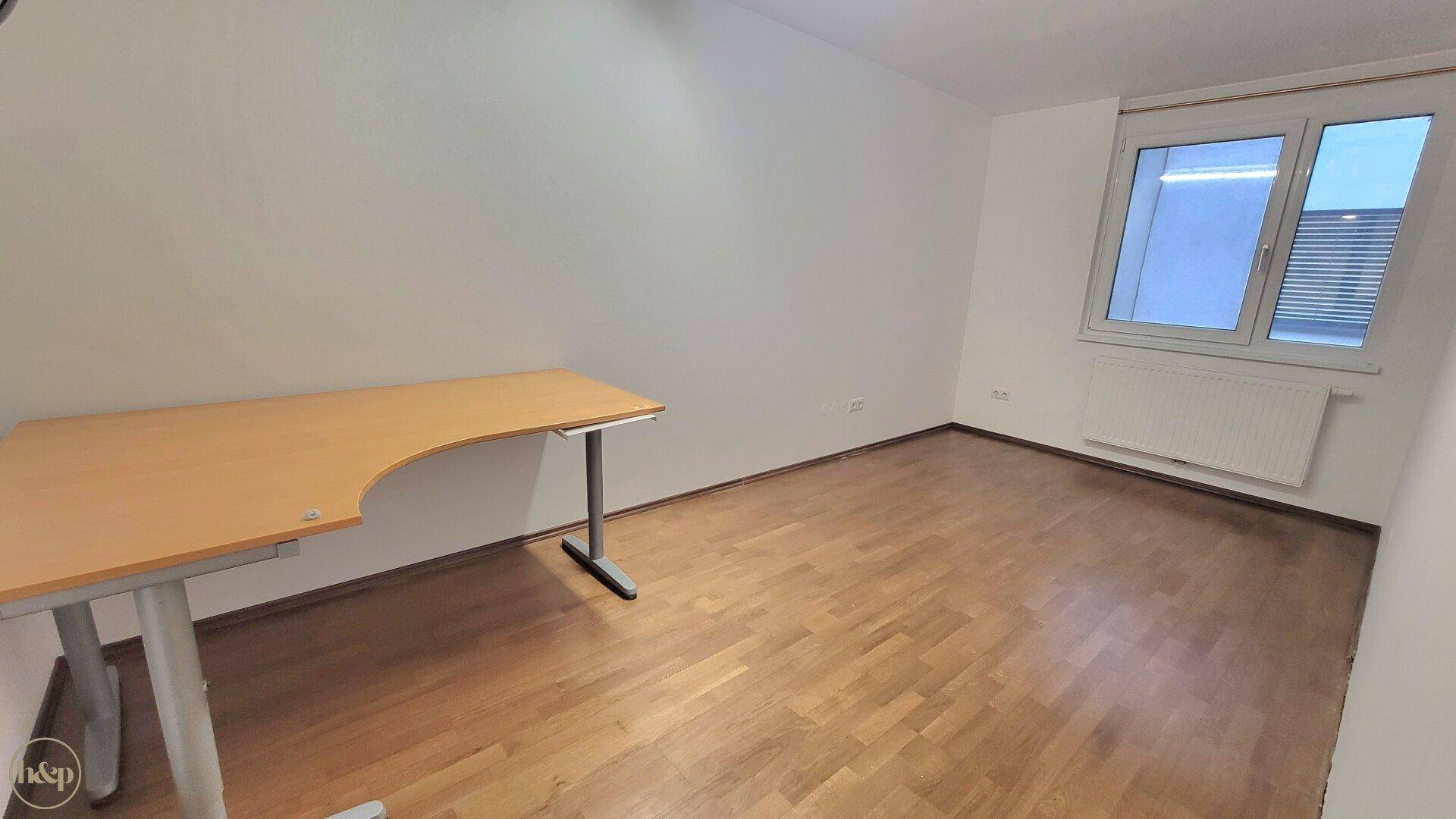 Helles Arbeitszimmer mit Schreibtisch und Fenster, ideal für Home-Office.