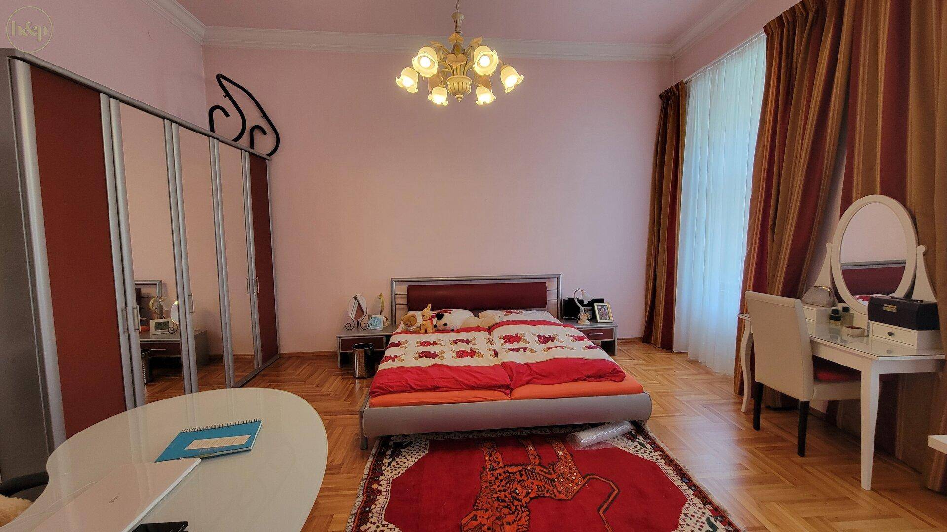 Geräumiges Schlafzimmer mit Parkettboden, Doppelbett und Spiegelschiebetürenschrank.