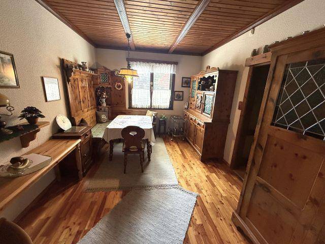 Rustikaler Essbereich mit Holzboden, Holzmöbeln und einer traditionellen Holzdecke.