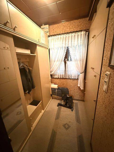 Praktischer Raum mit vielen Einbauschränken und einem Fenster, ideal als begehbarer Kleiderschrank.