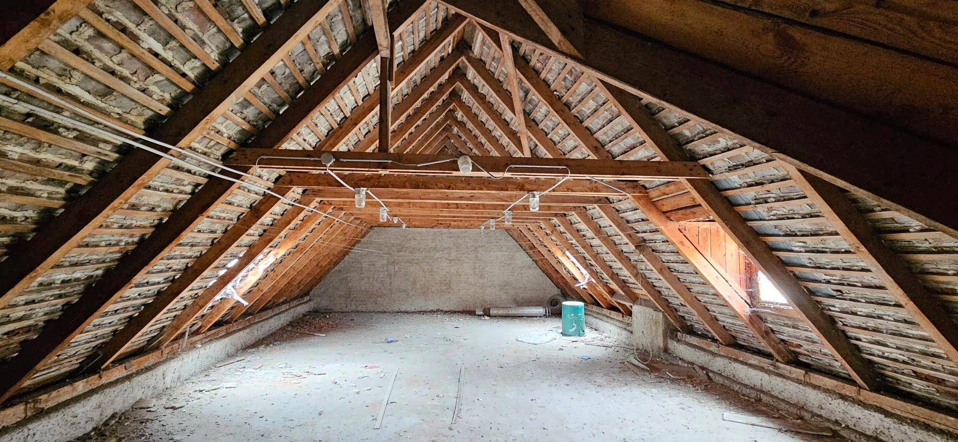 Unausgebauter Dachboden mit sichtbarer Holzkonstruktion und Dachschrägen, bereit für den Ausbau.
