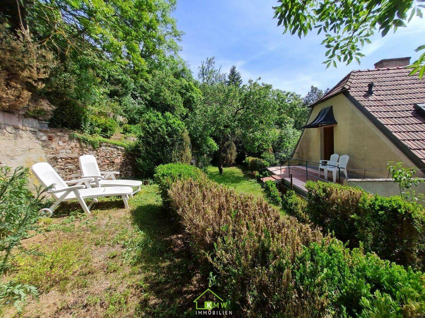 Gepflegter Garten mit Liegestühlen und Blick auf das Haus, ideal zum Sonnenbaden.
