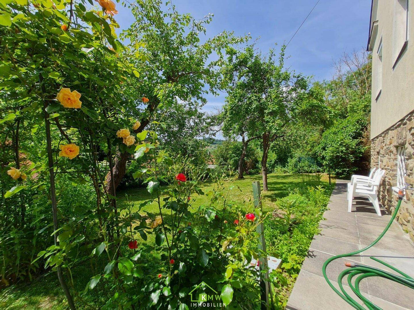 Blühender Rosengarten neben der Terrasse mit Blick ins Grüne.