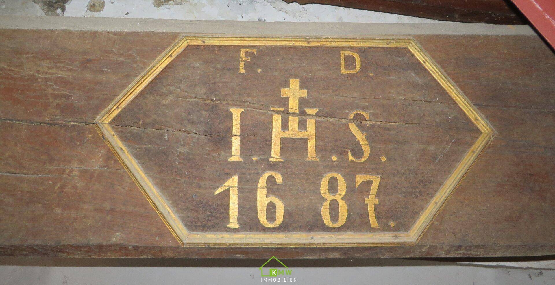 Historischer Holzbalken mit geschnitzter Inschrift und Jahreszahl 1687.