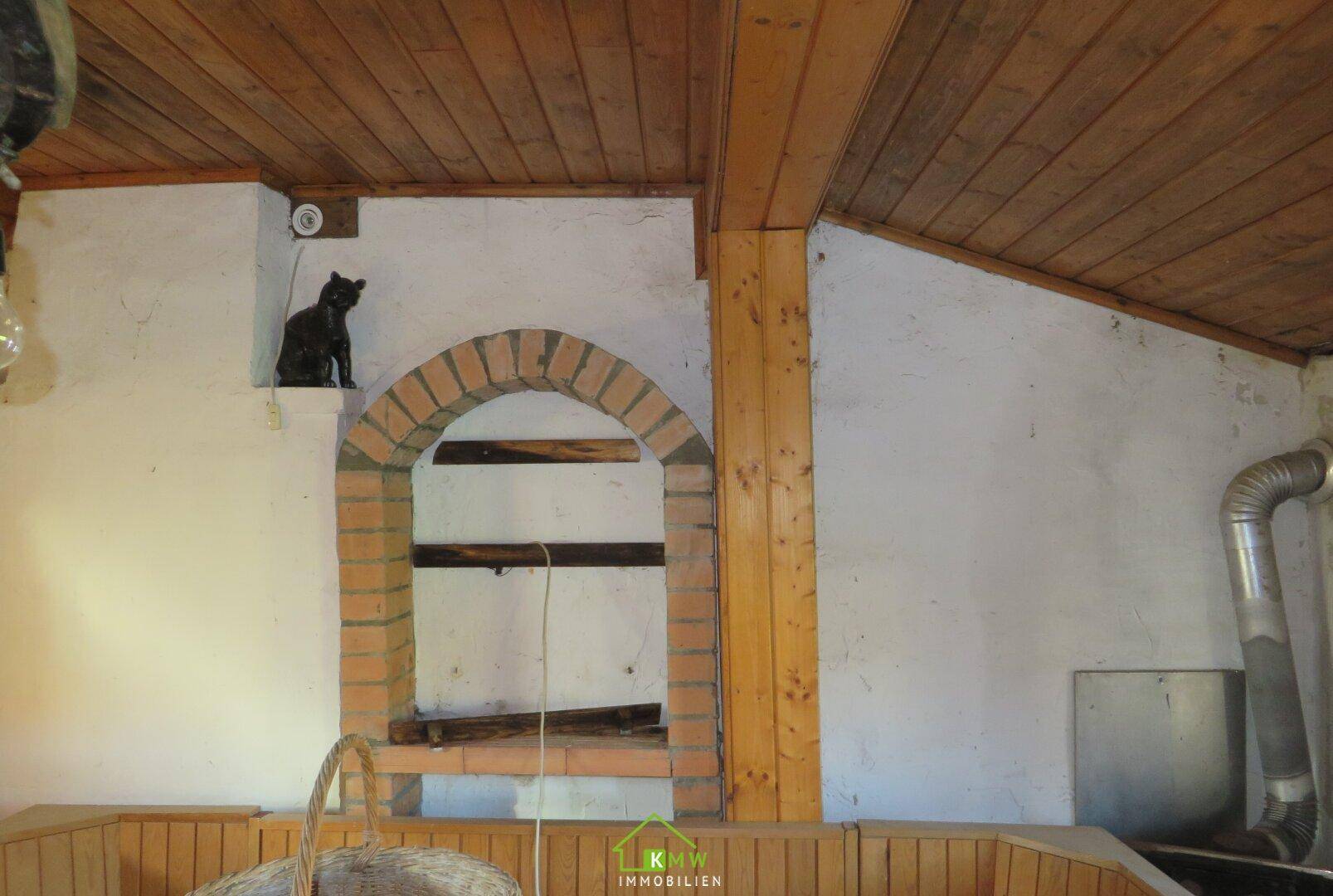 Gemauerter Bogen in einem Dachgeschossraum, möglicherweise ein alter Kaminbereich.