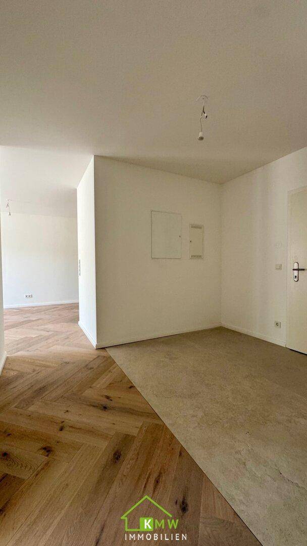 Heller Innenbereich mit Übergang zwischen Fischgrätparkett und Fliesenboden.