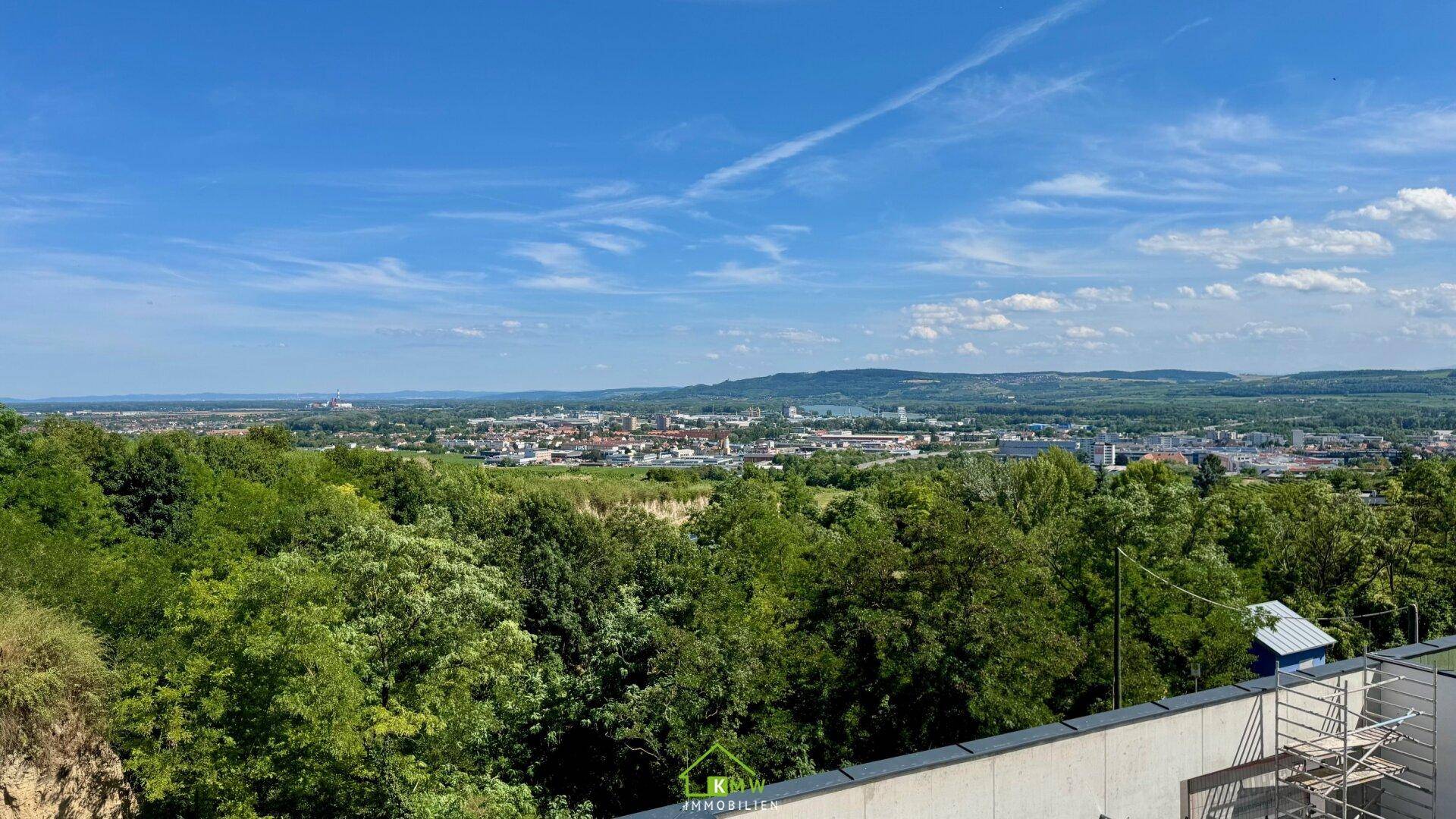 Panoramablick über die Stadt und grüne Landschaft von einer erhöhten Position.