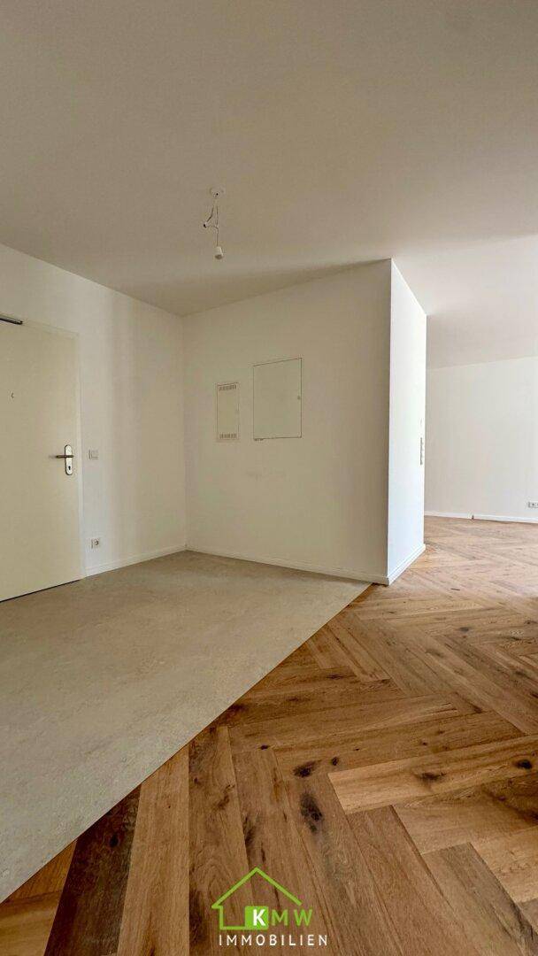 Heller Innenraum mit Übergang von hellem Boden zu elegantem Fischgrätparkett.