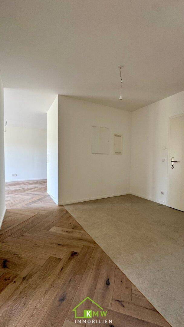 Heller Flurbereich mit Fischgrätparkett und Übergang zu einem Teppichboden in einem modernen Zuhause.
