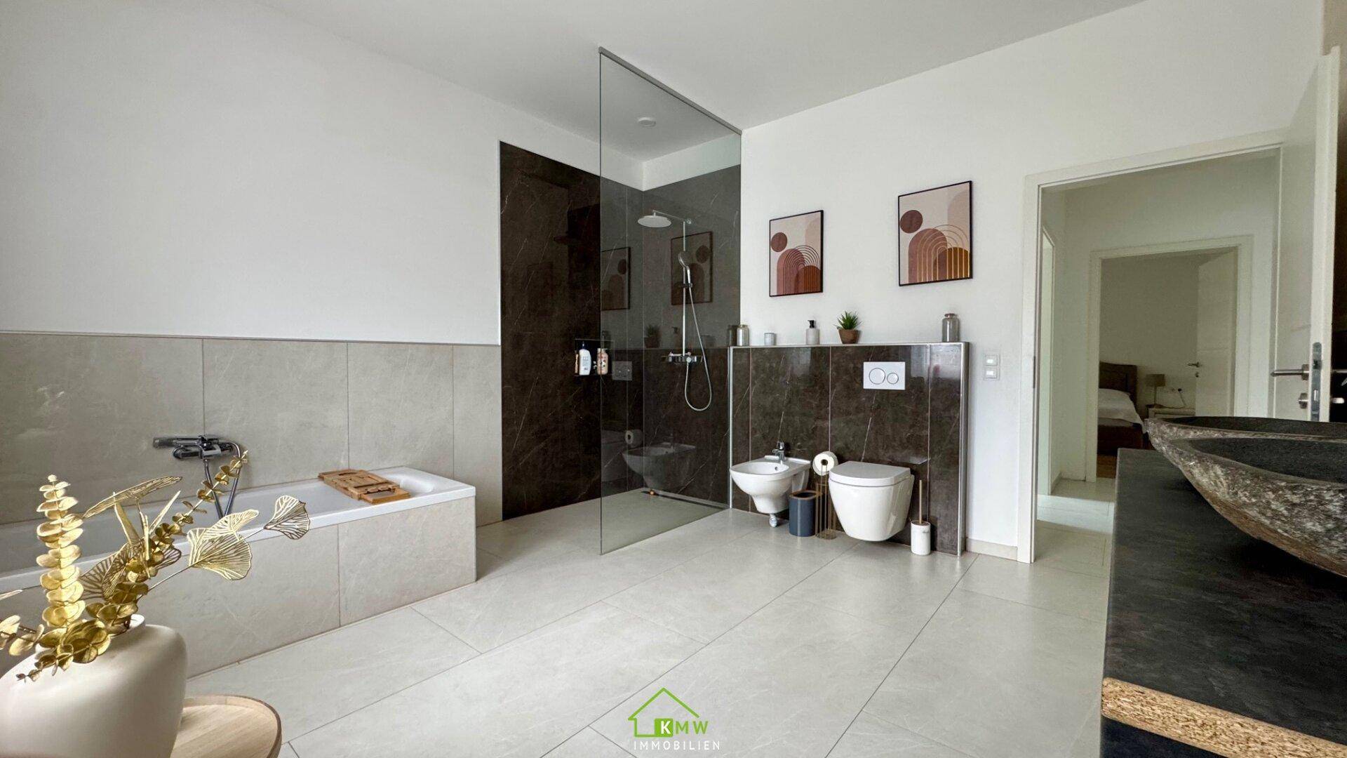 Modernes Badezimmer mit Badewanne, ebenerdiger Dusche und stilvollen Fliesen.