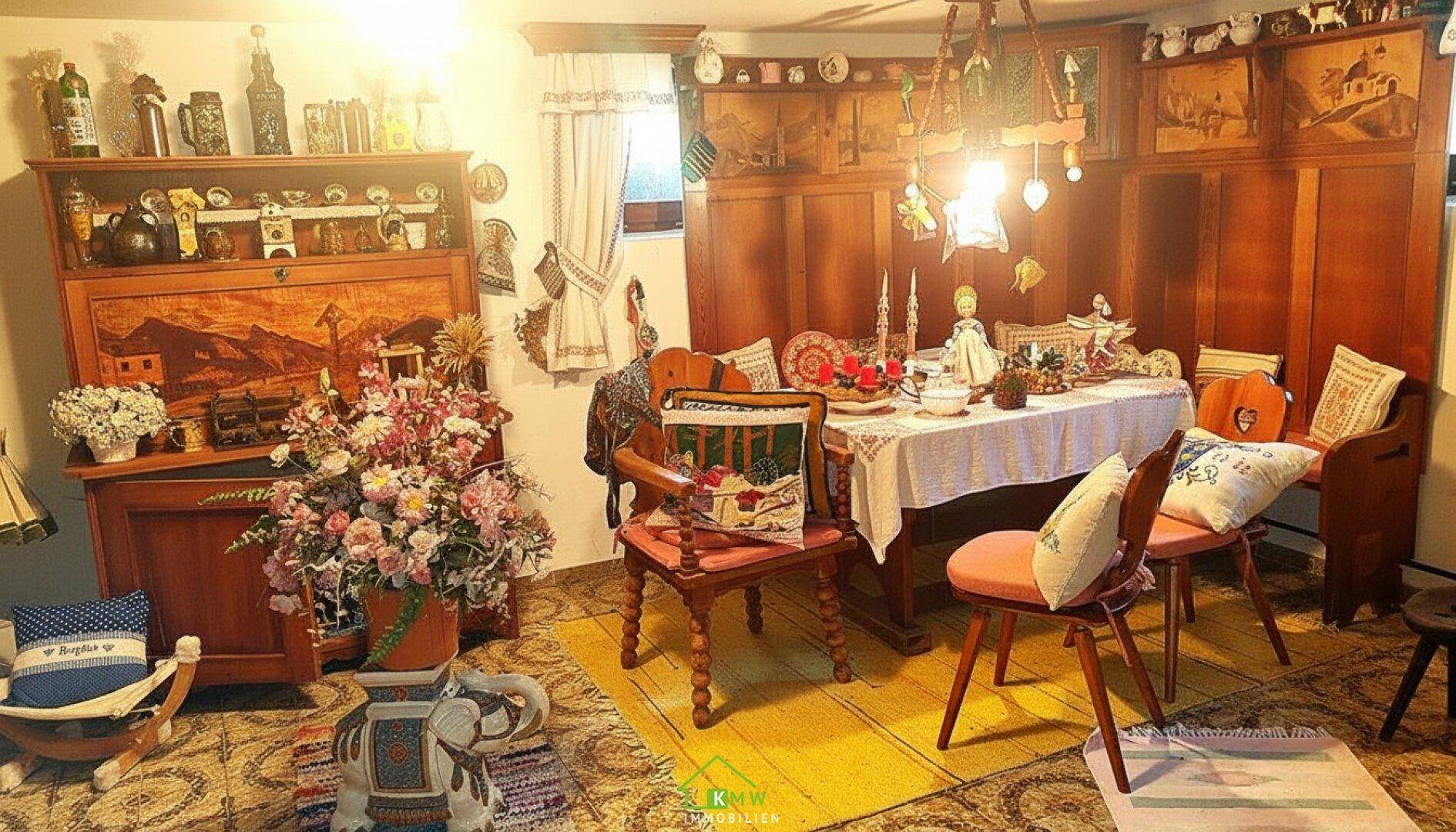 Traditioneller Essbereich mit Holztisch, Stühlen und rustikaler Dekoration in warmen Farben.