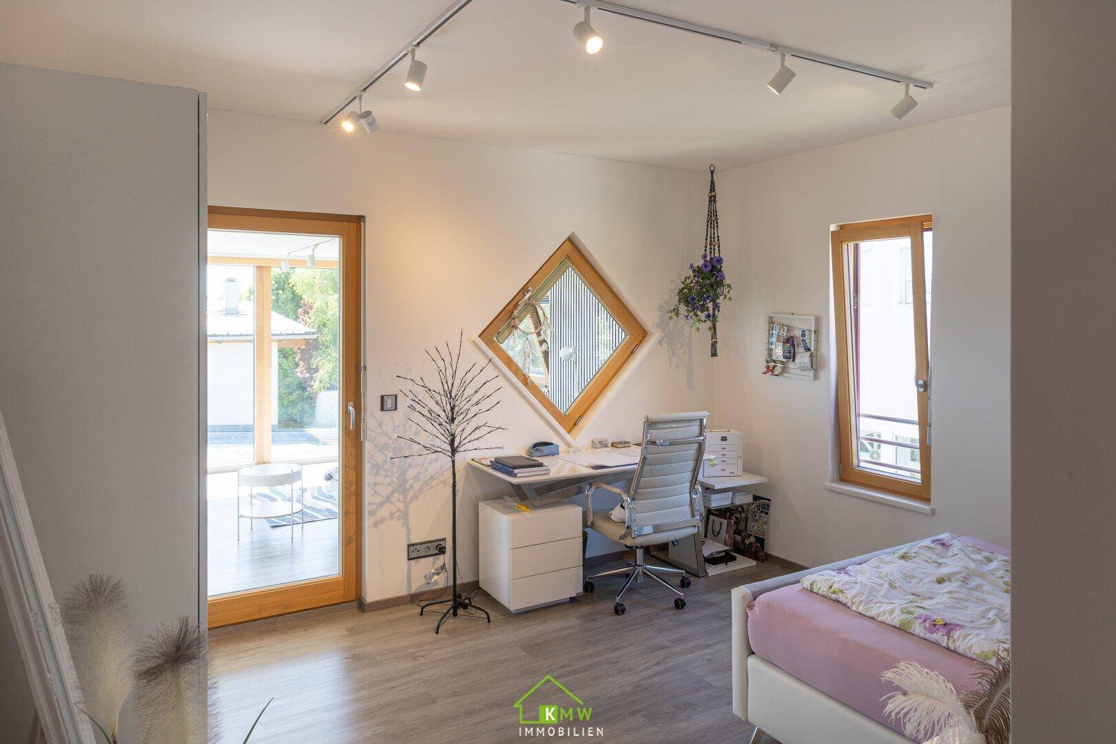 Helles Arbeitszimmer mit Schreibtisch, großem Fenster und Zugang zum Wintergarten.