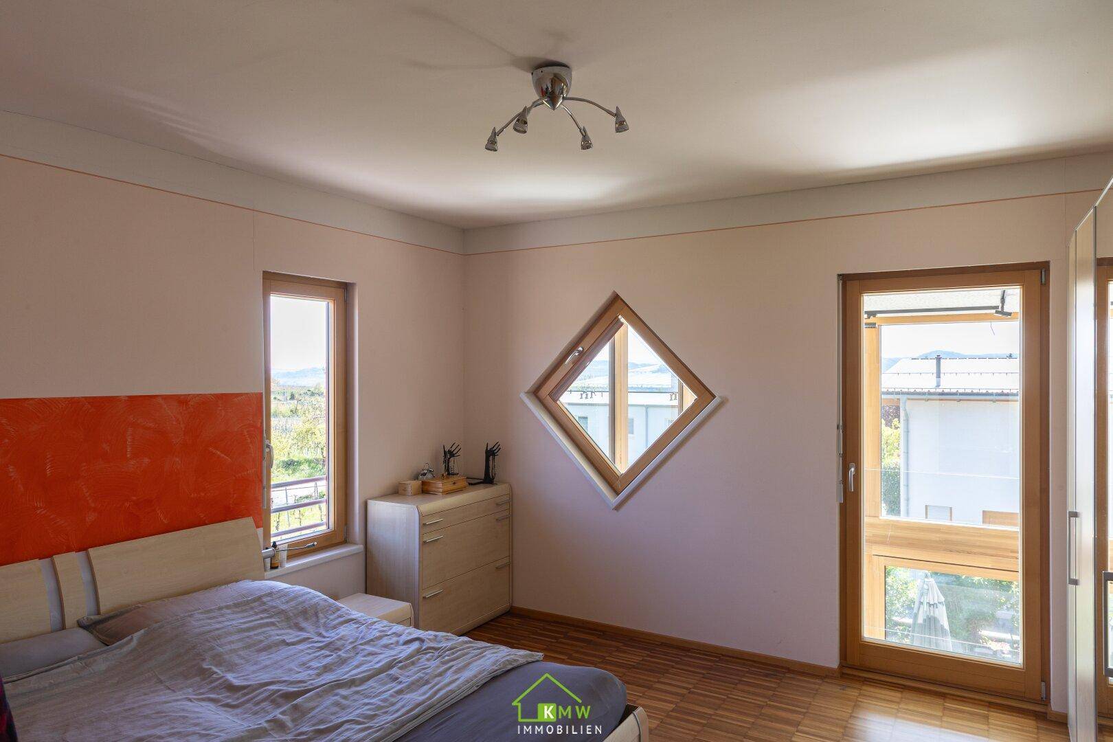 Schlafzimmer mit Doppelbett, Holzboden und Zugang zu einem Balkon oder Terrasse.