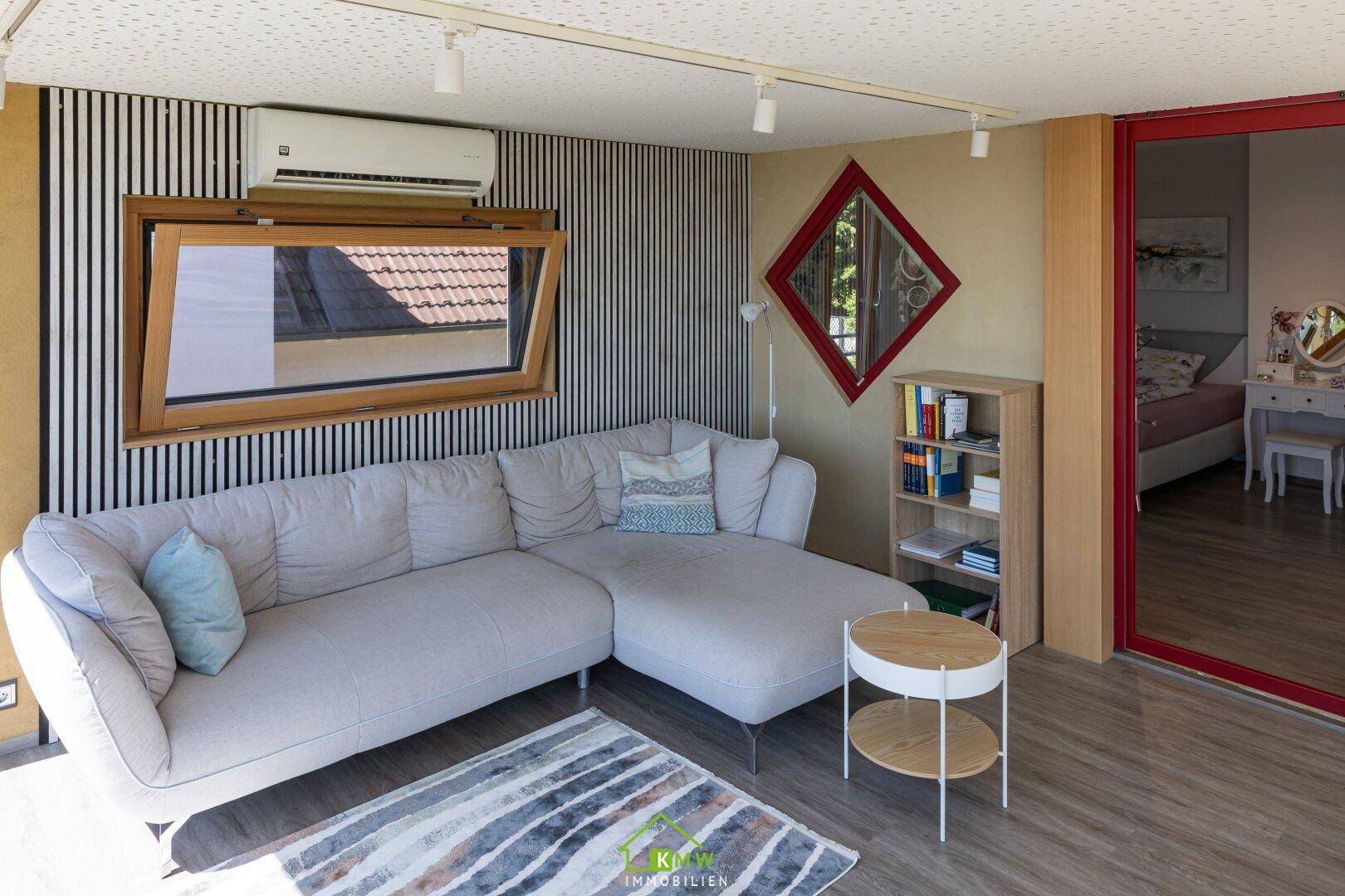 Gemütlicher Wohnbereich mit Ecksofa, Klimaanlage und Blick auf die umliegende Landschaft.