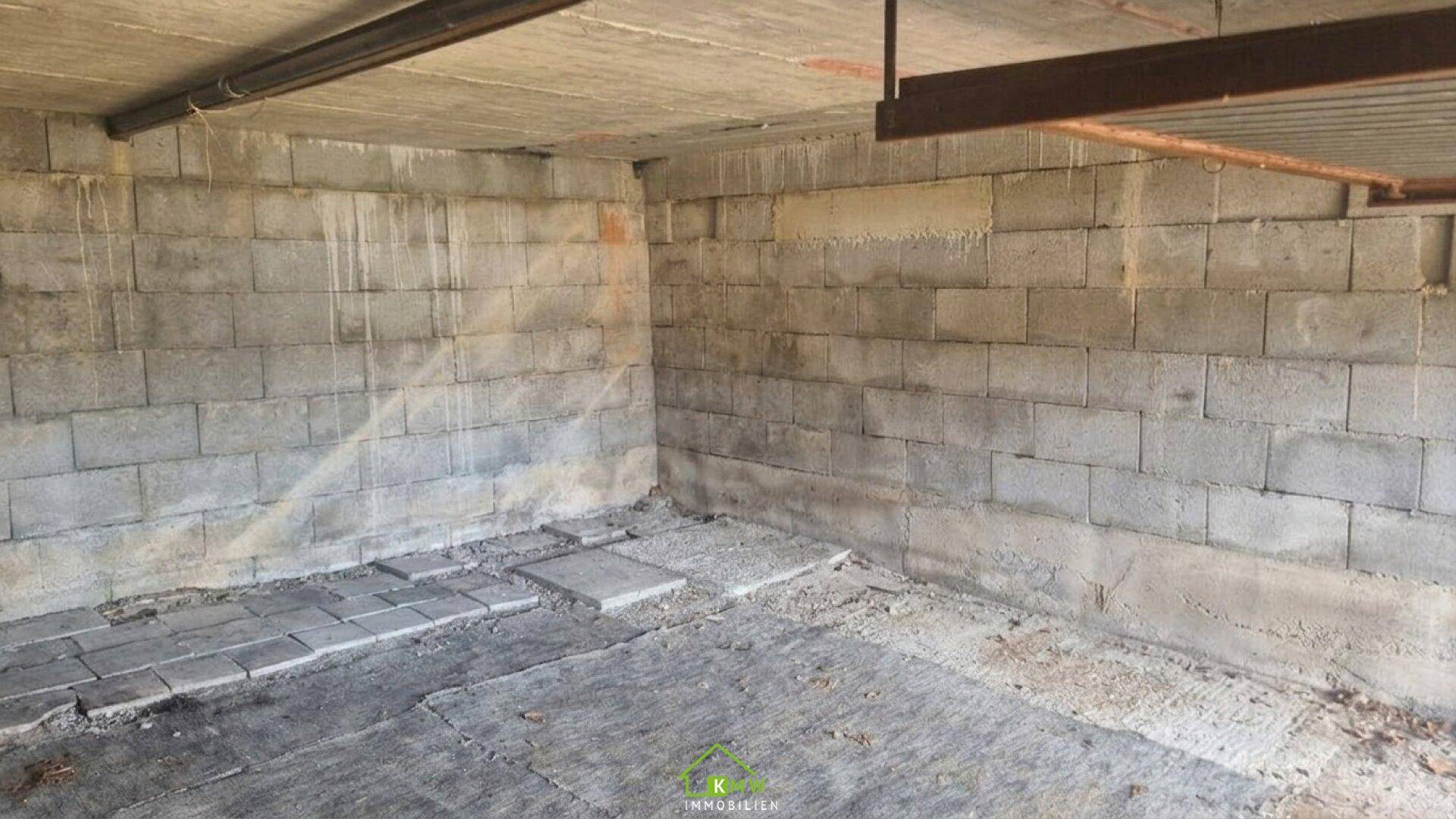 Unausgebauter Kellerraum mit Betonsteinwänden und einem einfachen Betonboden, ideal als Lagerfläche.