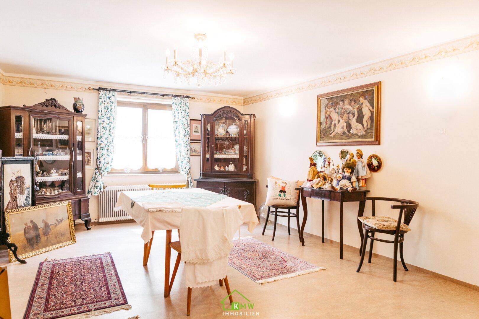 Geräumiges Esszimmer mit traditionellen Holzmöbeln, Kronleuchter und dekorativen Elementen.