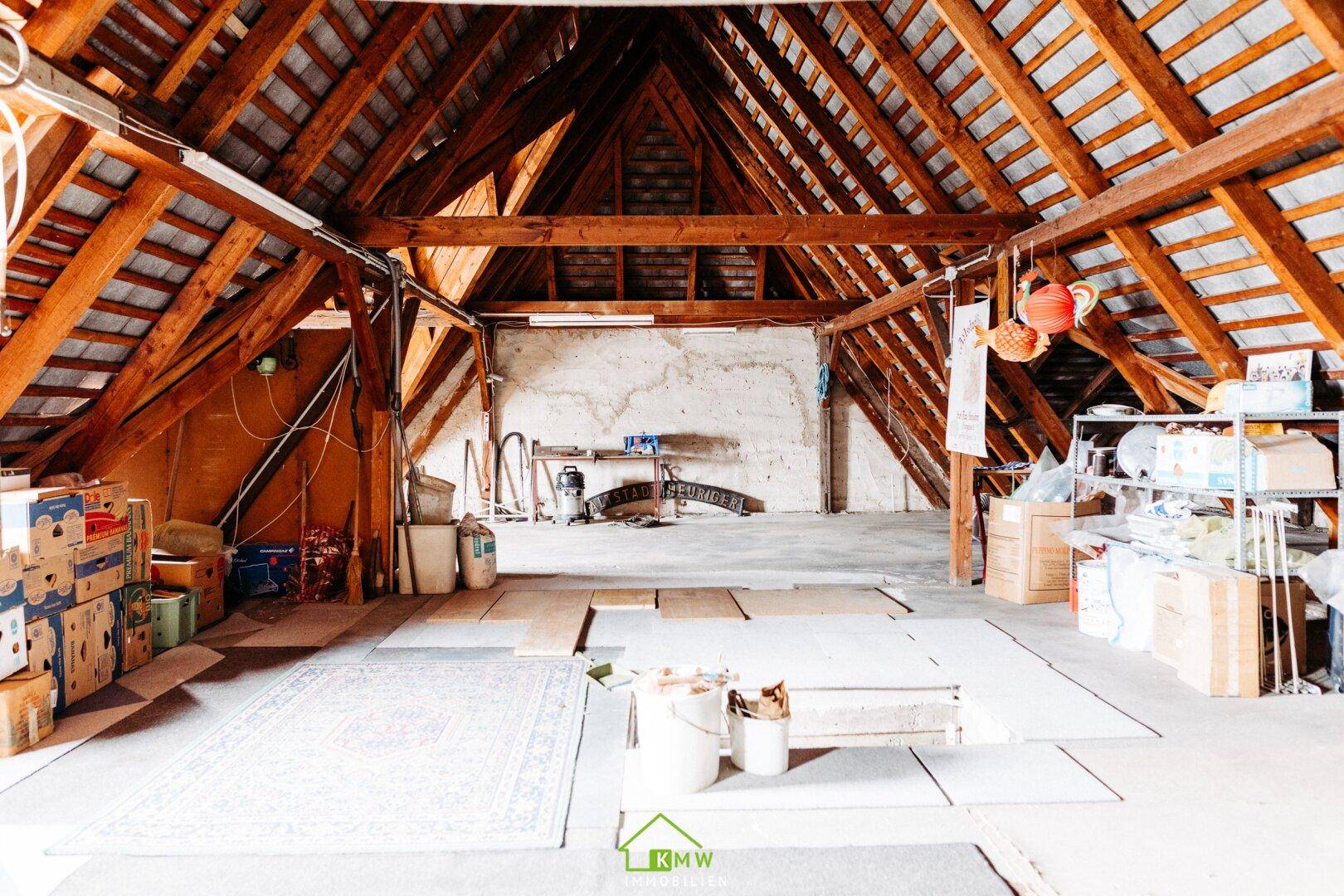 Geräumiger Dachboden mit sichtbaren Holzbalken und viel Stauraum, ideal für Ausbau.