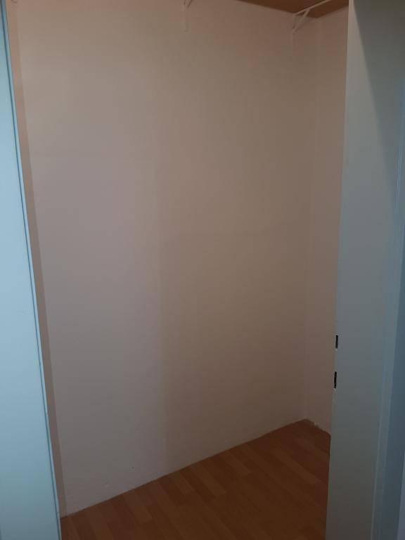 Kleiner, leerer Raum mit Holzparkettboden, ideal als Abstellraum oder begehbarer Kleiderschrank.
