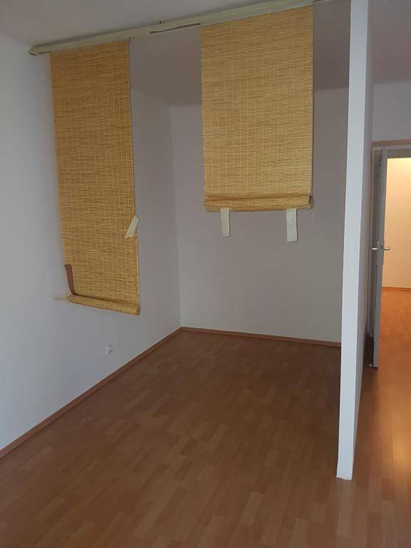 Heller Raum mit Holzparkettboden und dekorativen Bambusrollos, die den Bereich abgrenzen.