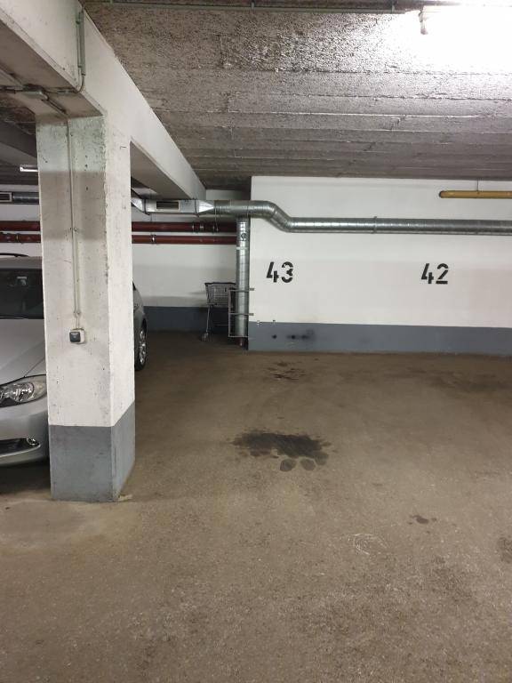 Tiefgarage mit Betonpfeilern, sichtbaren Leitungen und markierten Stellplätzen 42 und 43.