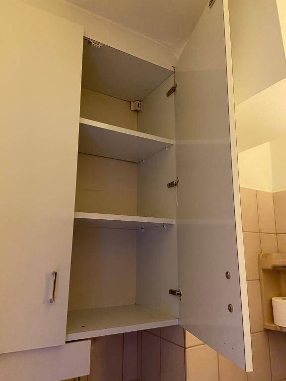 Offener Wandschrank mit Regalböden über dem Waschbereich im Badezimmer.