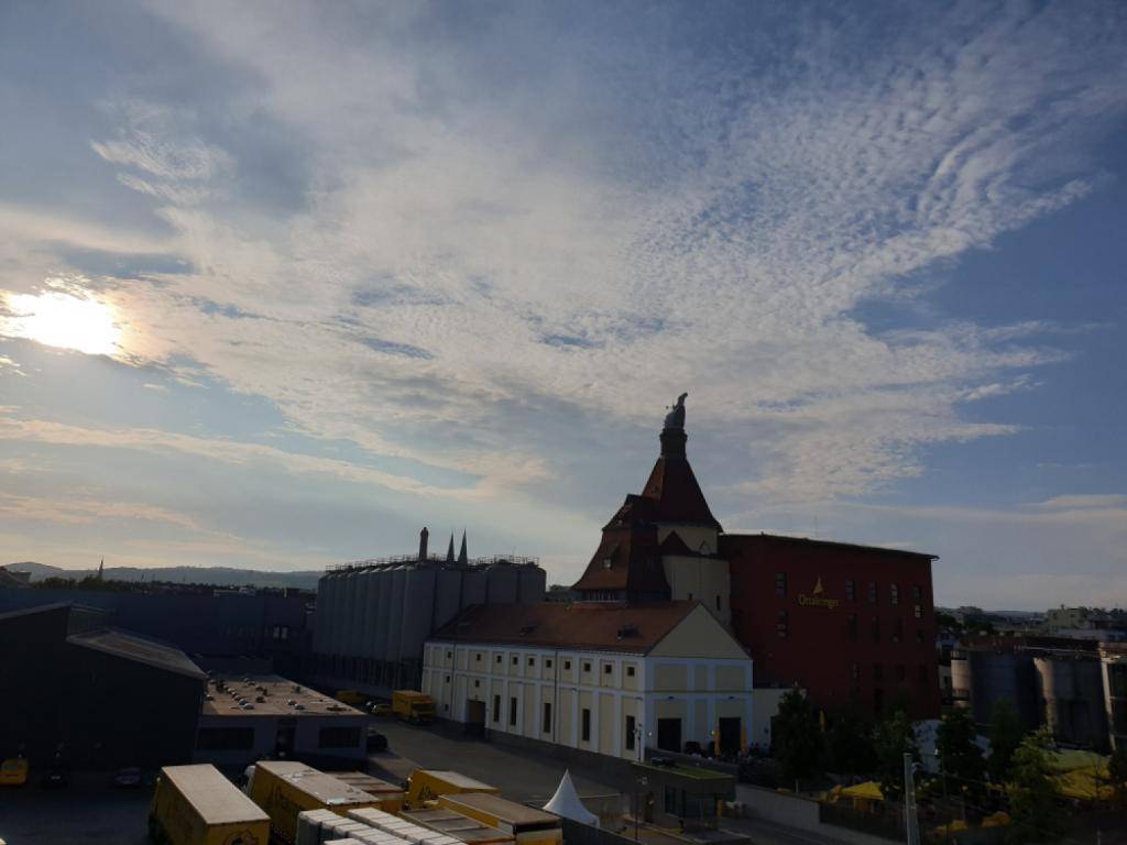 Panoramablick über eine städtische Landschaft mit Industriegebäuden und einem markanten Kirchturm.