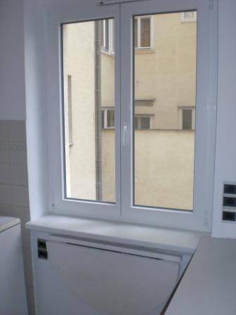 Fenster in der Küche mit Blick auf ein gegenüberliegendes Gebäude.