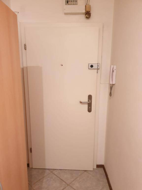 Wohnungseingangstür von innen mit Gegensprechanlage und Sicherungskasten darüber.