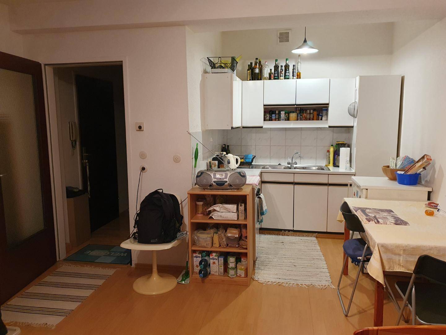 Kleine Küche mit Essbereich und weißen Schränken.
