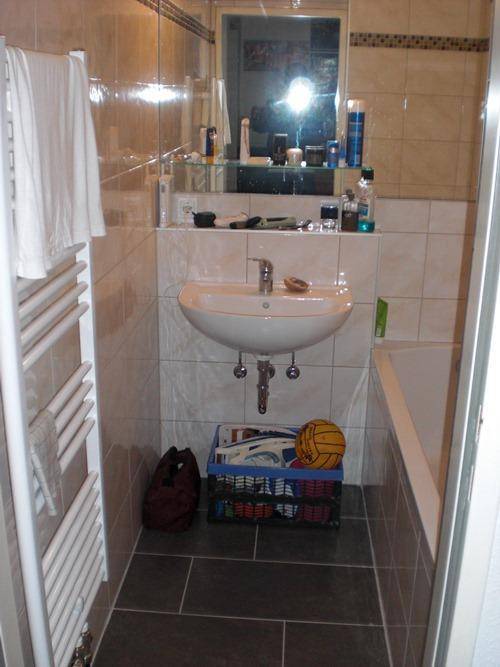 Helles Badezimmer mit Badewanne, Waschbecken und praktischem Handtuchheizkörper.