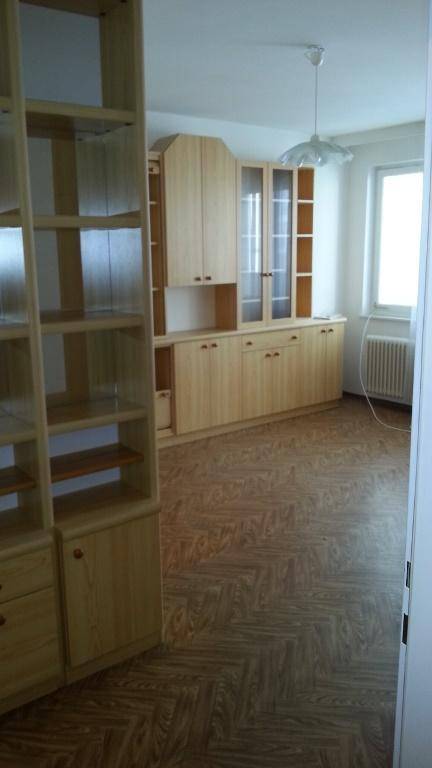 Heller Wohnbereich mit umfangreichen Holzschränken und Laminatboden, bereit zur Einrichtung.