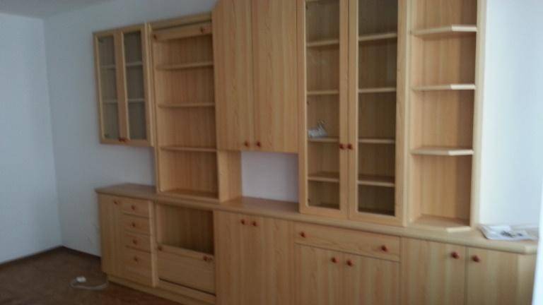 Umfangreiche Holzschrankwand mit Vitrinen und Schubladen, bietet viel Stauraum.