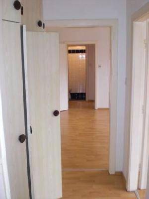 Heller Flur mit Holzboden und Zugang zu verschiedenen Räumen der Wohnung.