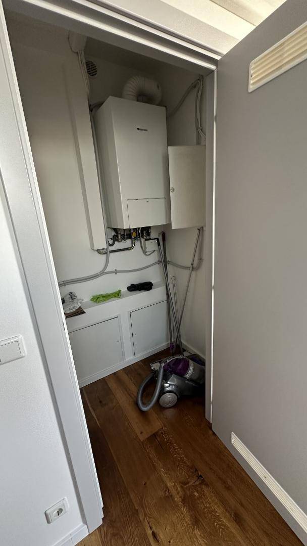 Praktischer Abstellraum mit Heizungsanlage und Stauraum für Haushaltsgeräte.
